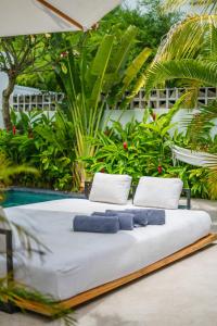 チャングーにあるVilla Mellow - Lovely 2 bdr villa close to the beach in Canggu !のベッド1台(上に青いタオル2枚付)