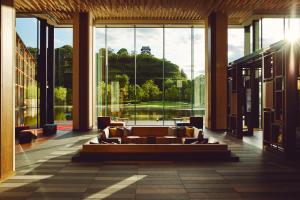 Una sala de estar con un sofá y grandes ventanales. en Hotel Indigo Inuyama Urakuen Garden by IHG, en Inuyama