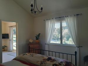 sypialnia z łóżkiem i oknem w obiekcie Kuaotunu's Peebles Cottage w mieście Kuaotunu