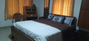 Schlafzimmer mit einem Bett, einer Kommode und einem Fenster in der Unterkunft NEST Mdy in Mananthavady