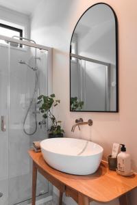a bathroom with a large white sink and a shower at Koa Cabin Hahei in Hahei