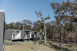 una fila de casas modulares en el bosque en Beach & Bay Stay Motel, en Callala Beach