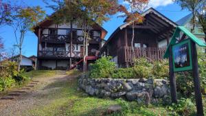 a house with a sign in front of it at フォレスト倶楽部　田園 in Takano