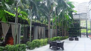 um pátio com palmeiras e cadeiras e um edifício em Large 3-Bedroom Modern Resort Style KLCC Apartment em Kuala Lumpur