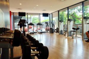 a gym with rows of treadmills and exercise machines at Large 3-Bedroom Modern Resort Style KLCC Apartment in Kuala Lumpur
