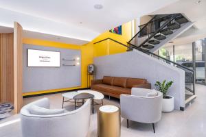 a lobby with a couch and a table and chairs at Mercure Rockhampton in Rockhampton