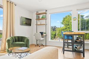 a living room with a couch and a desk and a window at NEW Bright Capitol Hill Condo, Great Location Views in Seattle