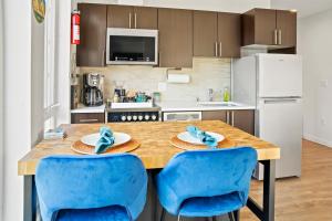 uma cozinha com uma mesa de madeira e cadeiras azuis em NEW Bright Capitol Hill Condo, Great Location Views em Seattle