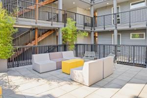 a patio in the courtyard of a building with a couch and tables at NEW Bright Capitol Hill Condo, Great Location Views in Seattle