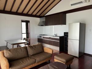 a living room with a couch and a kitchen at Ocean Hills Kouri in Nakijin