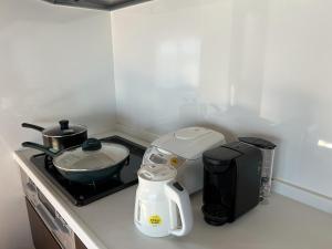 um balcão de cozinha com comodidades para preparar café e um liquidificador em Ocean Hills Kouri em Nakijin