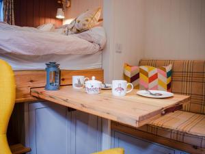 Little Willows في Potterne: طاولة مع أكواب وأطباق على سرير بطابقين