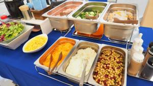 une table recouverte de plateaux de nourriture sur une table bleue dans l'établissement Toyoko Inn Tokyo Keio-sen Higashi-fuchu-eki Kita-guchi, à Fuchu