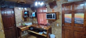 a bathroom with a sink and a tv on a wall at Apartotel VILLA ALTA TAMARINDO in Tamarindo