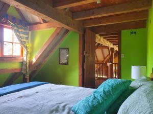 sypialnia z łóżkiem i zieloną ścianą w obiekcie Streamside Country Manor w mieście Walton