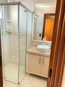 ボンビーニャスにあるDuplex Costa Esmeraldaのガラスのシャワーと洗面台を備えたバスルーム
