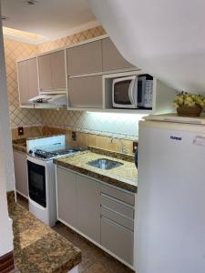ボンビーニャスにあるDuplex Costa Esmeraldaのシンクと電子レンジ付きのキッチン