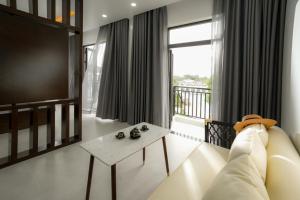 DAD Resort Phú Quốc في فو كووك: غرفة معيشة مع أريكة وطاولة ونافذة