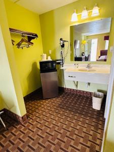 baño con lavabo y espejo grande en American Inn Princeton, en Princeton