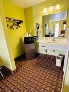 a bathroom with a sink and a large mirror at American Inn Princeton in Princeton