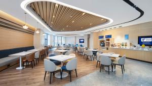 西安西安曲江中心智选假日酒店的有桌椅和酒吧的餐厅