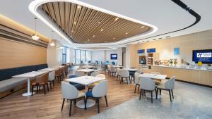 a restaurant with tables and chairs and a bar at Holiday Inn Express Xi'an Qujiang Center, an IHG Hotel in Xi'an