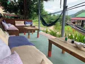a porch with a hammock and benches and a table at DAHLIA Guesthouse in Koh Rong Sanloem