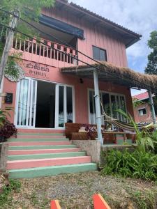 高龙撒冷岛DAHLIA Guesthouse的粉红色的房子前面设有楼梯