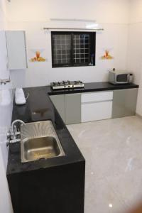 a kitchen with a sink and a counter top at Forest Sunrise Villa 3BHK in Mahabaleshwar