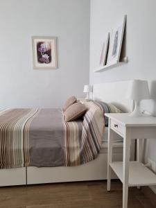 um quarto branco com uma cama e uma secretária branca em Happy Home em Catânia