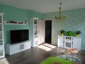 a living room with a flat screen tv and white cabinets at Ferienwohnung Apfeltraum in Thale
