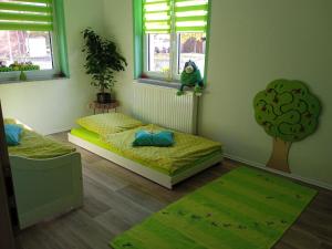 two beds in a room with two windows and a rug at Ferienwohnung Apfeltraum in Thale