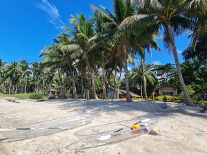 a group of kayaks on a beach with palm trees at Antique Amor Bungalows & Villas in Pandan