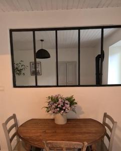 a dining room table with a mirror on the wall at Gite de la Châteldonnaise in Châteldon +13 photos