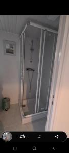 a shower with a glass door in a room at Gite de la Châteldonnaise in Châteldon