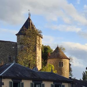 un edificio con una torre con una cruz. en Gite de la Châteldonnaise, en Châteldon