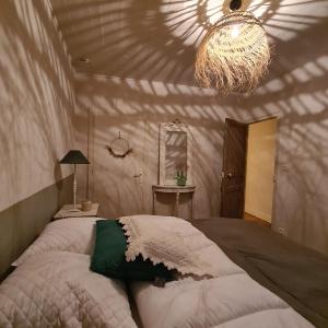 1 dormitorio con cama y lámpara de araña en Gite de la Châteldonnaise, en Châteldon