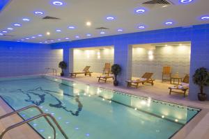a pool in a hotel room with chairs at Mariana Hotel Erbil in Erbil