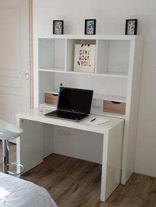 Un escritorio blanco con una computadora portátil encima. en Chambre au calme entourée par la nature., en Saint-Léon-sur-Vézère