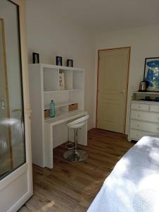 1 dormitorio con escritorio, 1 cama y vestidor en Chambre au calme entourée par la nature., en Saint-Léon-sur-Vézère 1 foto más