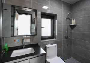 a bathroom with a toilet and a sink and two windows at Yosemite Riverview Homestay in Yichang