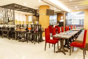 a restaurant with long tables and red chairs at FuramaXclusive Sukhumvit in Bangkok