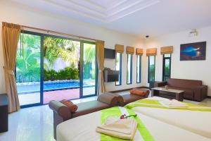 a bedroom with two beds and a living room at 3Z Pool Villa and Hotel in Ban Huai Yai