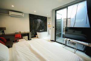 ein Schlafzimmer mit einem großen weißen Bett und einem großen Fenster in der Unterkunft Grand Park Resort in Ban Chorakhe Bua