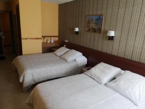 a hotel room with two beds and two lamps at Hotel Copacabana in Pas de la Casa