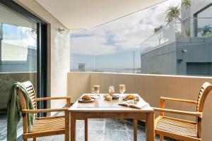 una mesa y sillas en un balcón con vistas en Houghton View 13 Luxury Apartments en Ciudad del Cabo