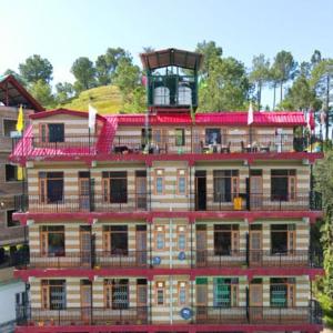 a tall red building with balconies on top of it at New Summer Capital in Shimla +26 photos