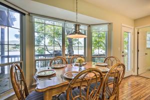 a dining room with a table and chairs and windows at Ideal Chickamauga Lake Home and Dock and Fire Pit in Soddy-Daisy