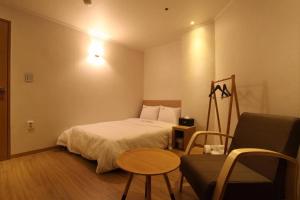 1 dormitorio con cama, mesa y sofá en Hotel Violet, en Goyang