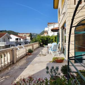 a balcony with a table and chairs on a building at Studio apartman in Meljine